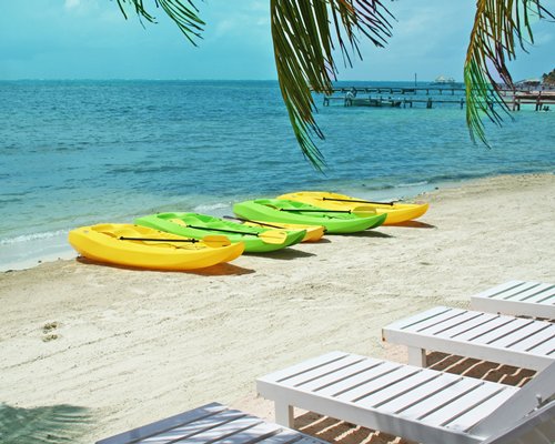 View of chaise lounge chairs and boats at the beach.