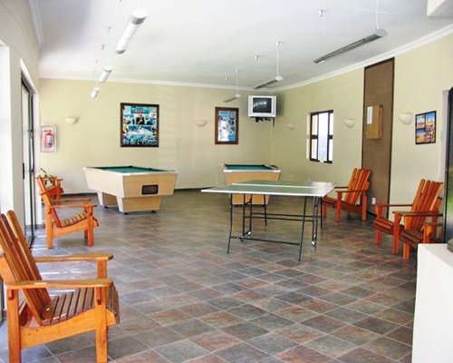 An indoor recreational area with two pool tables and ping pong.