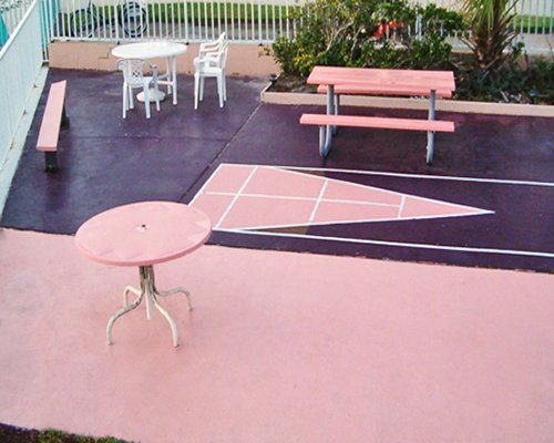 A shuffle board court alongside patio furniture.