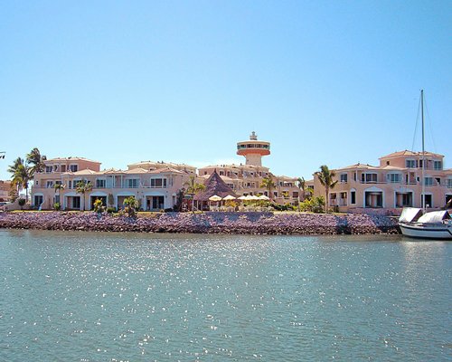 Exterior view of Isla Mazatlan alongside the ocean with a boat.