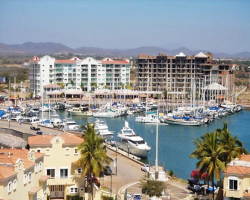 An exterior view of the multi story condo with a marina.
