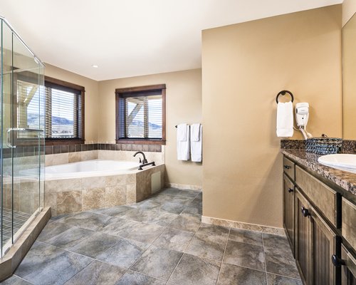 A large bathroom with a bathtub and single sink vanity.