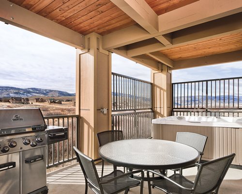 A balcony with patio furniture and a barbecue grill.