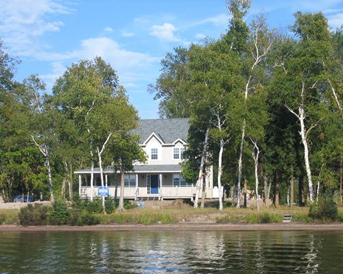 Exterior view of Marcus Beach cottages surrounded by trees alongside the lake.