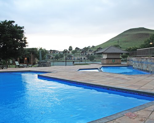 An outdoor swimming pool with chaise lounge chairs .
