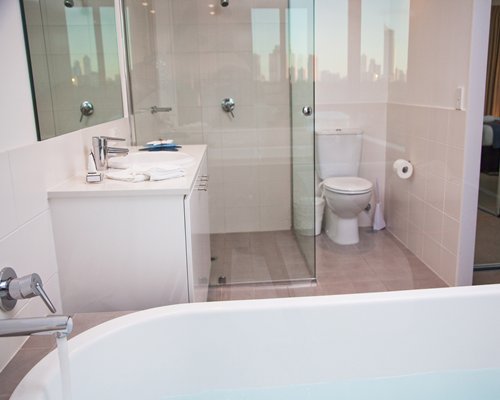 A bathroom with a bathtub shower and single sink vanity.