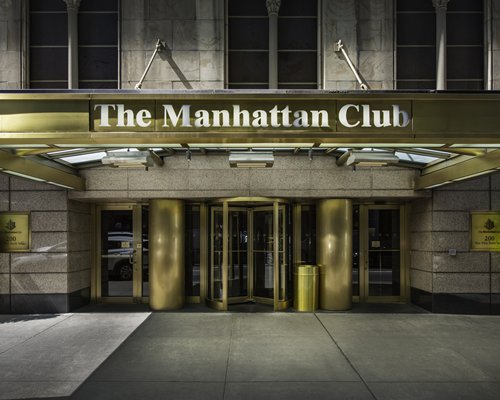 Street view of The Manhattan Club at night.
