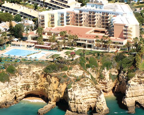 Scenic exterior view of Pestana Viking Ocean Suites with outdoor swimming pool alongside the beach.
