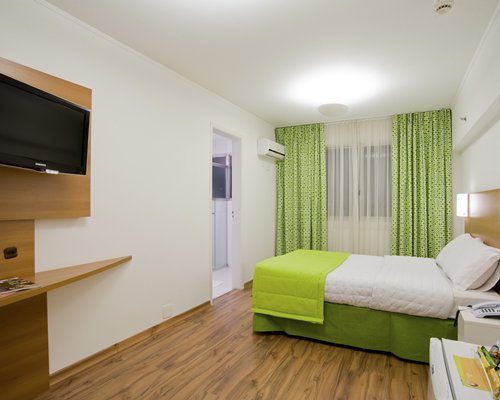 A well furnished bedroom with television.