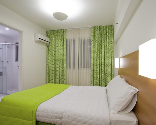 A well furnished bedroom alongside a stand up shower.