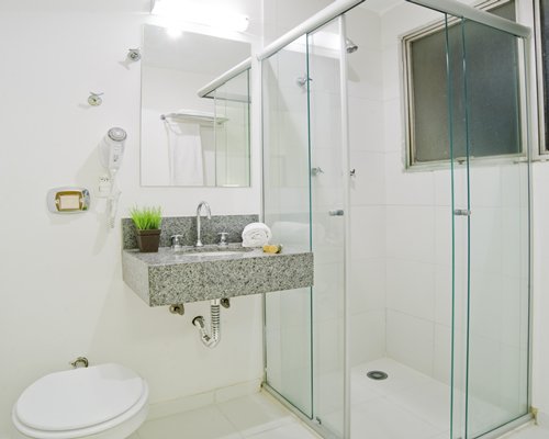 A bathroom with a sink and shower stall.