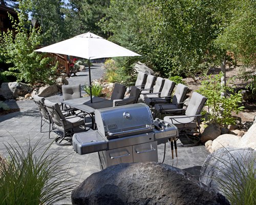 An outdoor picnic area with patio and barbecue grill.