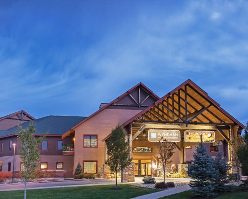 AN EXTERIOR VIEW OF WYNDHAM VACATION RESORTS AT GLACIER CANYON RESORT UNITS AT DUSK.