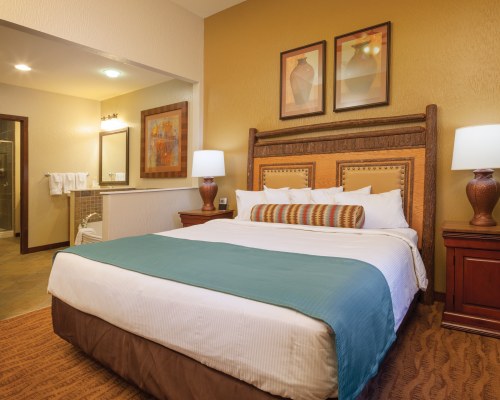 A WELL FURNISHED BEDROOM WITH TWO LAMPS.