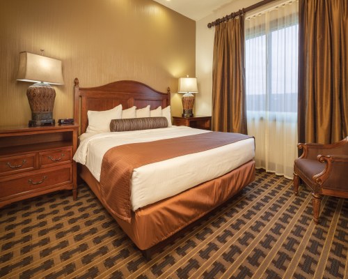 A WELL FURNISHED BEDROOM WITH AN OUTSIDE VIEW.