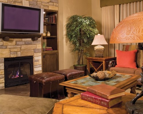 A WELL FURNISHED LIVING ROOM WITH A TELEVISION AND FIREPLACE.