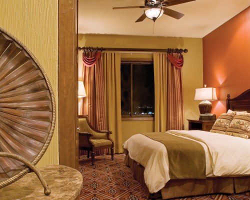 A WELL FURNISHED BEDROOM WITH PATIO FURNITURE AND OUTSIDE VIEW.