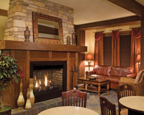 A WELL FURNISHED LIVING ROOM WITH A FIRE IN THE FIREPLACE AND DINING AREA.