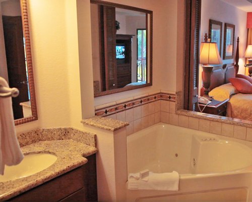A bathtub and single sink vanity adjacent the bedroom.