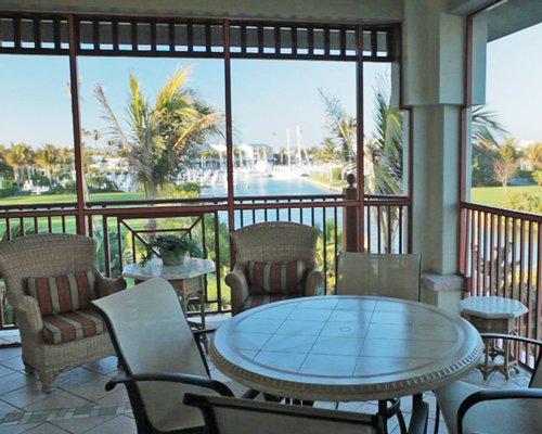 A balcony with patio furniture and the view of the swimming pool.