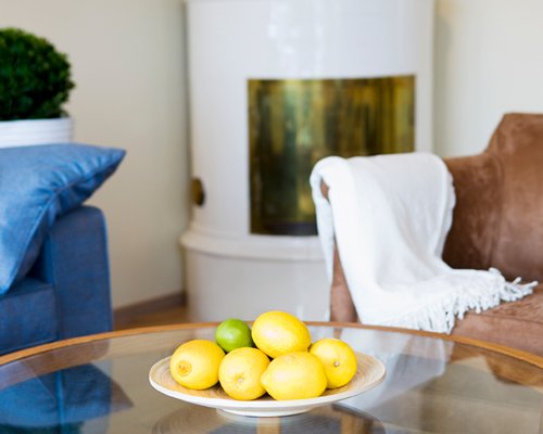 A view of fruits on a glass top table in the living room.