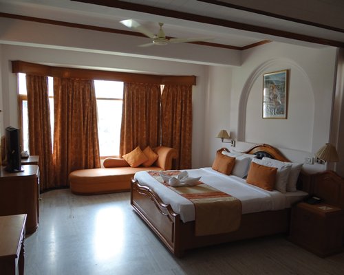 A well furnished bedroom with a television and outside view.