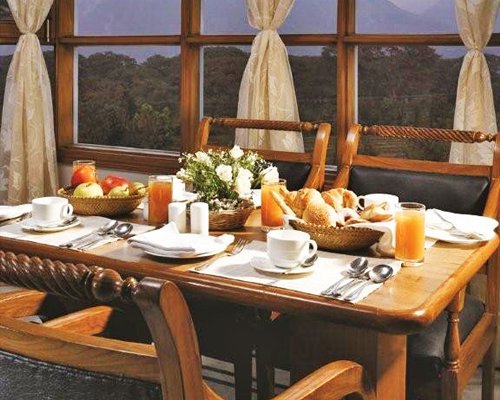 An indoor dining area with food items on the table.