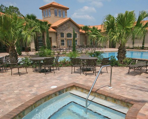 An outdoor patio with trees alongside the swimming pool.