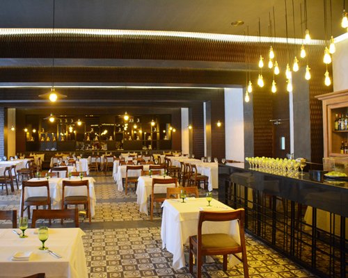 A fine dining restaurant interior with multiple dining tables and bar area.