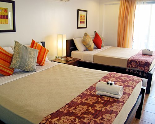 A well furnished bedroom with two queen beds and an outside view.