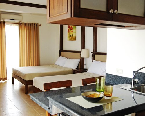 An open plan bedroom with a kitchen and breakfast bar.