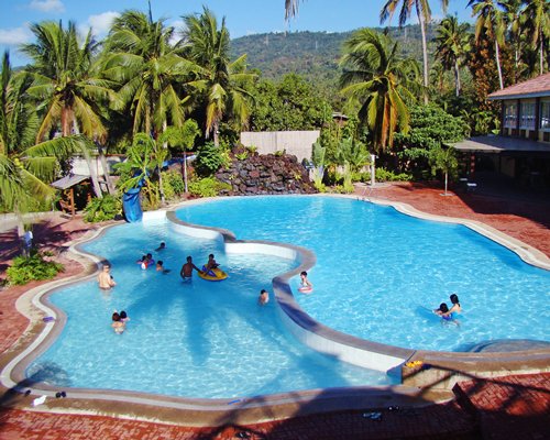 Large outdoor swimming pool with a slide.