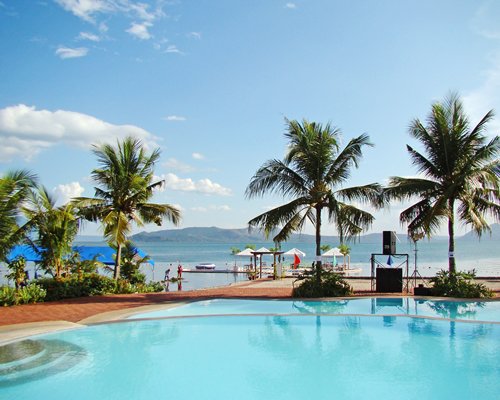 An outdoor swimming pool with trees alongside the waterfront.