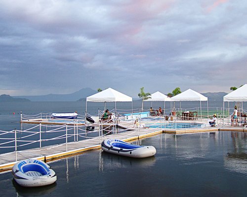 An outdoor swimming pool with patio surrounded by the lake.