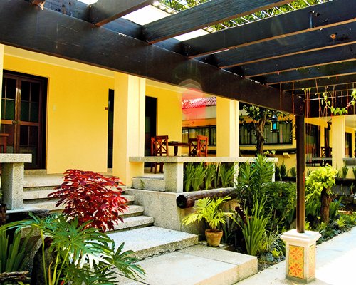 Entrance to a unit with stairway and landscaping.