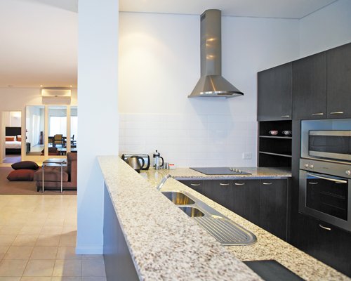 A well equipped kitchen alongside a living room.