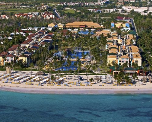 An aerial view of Ocean Blue & Sand surrounded by wooded area alongside the beach.