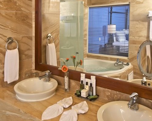 A bathroom with a bathtub shower and double sink vanity.