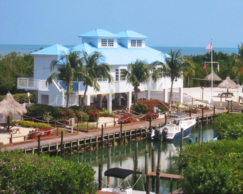 EXTERIOR VIEW OF OCEAN POINTE SUITES @ KEY LARGO ALONGSIDE THE WATERFRONT WITH BOATS.