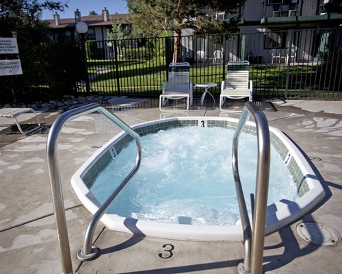 An outdoor hot tub with chaise lounge chairs.