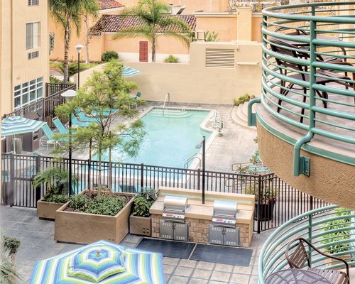 Balcony view of the outdoor swimming pool and grilling area.