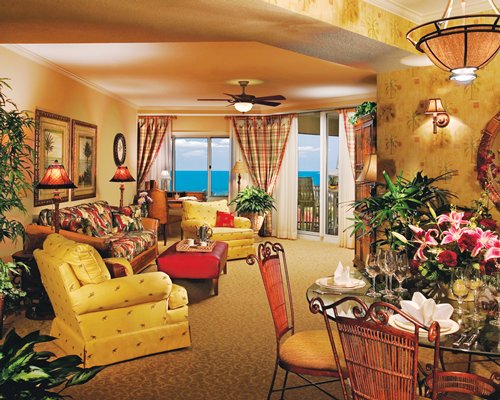 A well furnished living room with dining area balcony and ocean view.