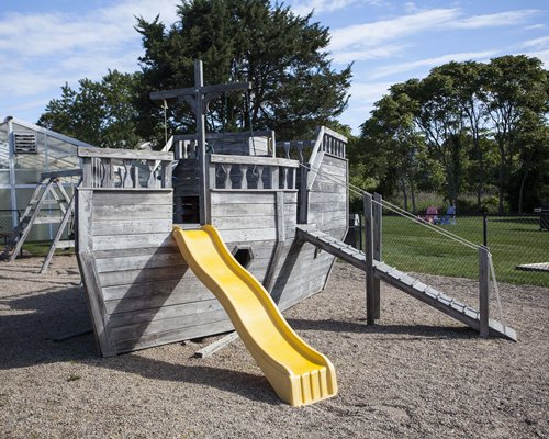 An outdoor playground slide with trees.