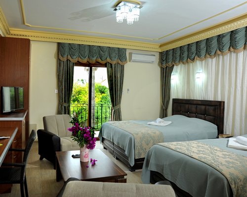 A well furnished bedroom with a balcony.