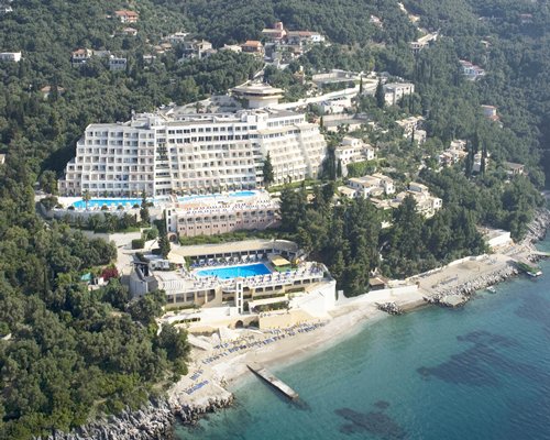 An aerial view of Sunshine Rhodes resort surrounded by trees alongside the sea.
