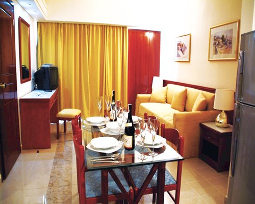 A well furnished open plan living and dining area with a television.