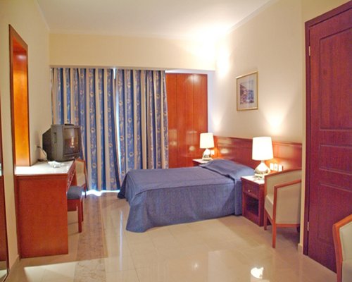 A well furnished bedroom with a double bed and television.