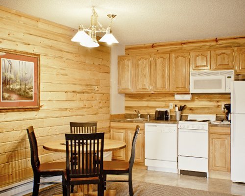 A well equipped kitchen with a wooden dining area.