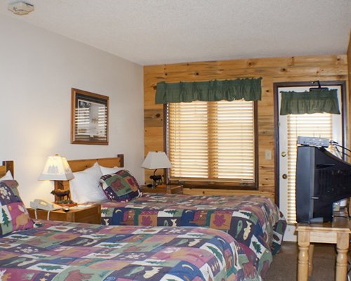 A well furnished bedroom with two beds and a television.