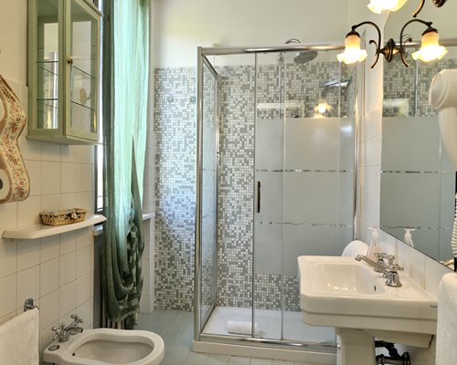 A bathroom with stand up shower and single sink vanity.